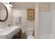 Tiled bathroom featuring a modern sink and a shower with a shower curtain for added privacy at 2202 Bearskin Ln, Monroe, NC 28110