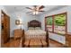 Cozy bedroom featuring wood floors, a ceiling fan, and a view of the backyard at 2202 Bearskin Ln, Monroe, NC 28110