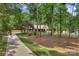 Long driveway leading to a brick home with a welcoming front porch and lush, wooded surroundings at 2202 Bearskin Ln, Monroe, NC 28110