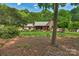 View of a well-maintained brick home with a large front yard and mature trees surrounding the property at 2202 Bearskin Ln, Monroe, NC 28110