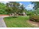 Brick home featuring a circular driveway, manicured lawn, mature tree, and welcoming front porch at 2202 Bearskin Ln, Monroe, NC 28110