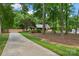 Landscaped front yard with a long driveway, trees, and green grass leading to a single-story home at 2202 Bearskin Ln, Monroe, NC 28110