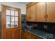 Kitchen features wooden cabinetry, sleek countertops, and door to exterior at 2202 Bearskin Ln, Monroe, NC 28110
