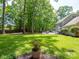 Expansive backyard with a spacious deck, mature trees, and lush green lawn at 2329 Wedgewood Dr, Matthews, NC 28104