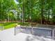 View of the backyard from the grey wooden deck, with grass yard and lush mature trees at 2329 Wedgewood Dr, Matthews, NC 28104