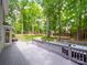 A view of the backyard deck, grass yard, and lush mature trees at 2329 Wedgewood Dr, Matthews, NC 28104