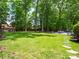 Lush backyard with mature trees, a seating area, and stone pathway at 2329 Wedgewood Dr, Matthews, NC 28104