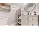 Neat bathroom featuring white vanity with black hardware, open storage, and a modern round mirror at 2329 Wedgewood Dr, Matthews, NC 28104