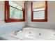 Inviting bathroom featuring a large soaking tub, beautiful tile, and natural light from two windows at 2329 Wedgewood Dr, Matthews, NC 28104