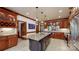 Gourmet kitchen boasts a large island with sink and granite countertop, custom cabinets, and tile flooring at 2329 Wedgewood Dr, Matthews, NC 28104