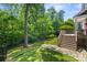 Private backyard with a deck, lush greenery, and a secure black fence at 2311 Club Rd, Charlotte, NC 28205