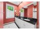 Bathroom with double sinks, black granite countertop, large mirror, and natural light at 2311 Club Rd, Charlotte, NC 28205