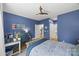 Stylish blue bedroom featuring a work space, ceiling fan, and doors leading to the kitchen and bathroom at 2311 Club Rd, Charlotte, NC 28205