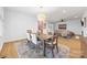 Open-concept dining area featuring a wooden table, modern lighting, and seamless flow to the living room at 2311 Club Rd, Charlotte, NC 28205