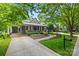 Charming home with a well-manicured lawn, beautiful landscaping, and a cozy front porch at 2311 Club Rd, Charlotte, NC 28205