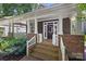 Inviting front porch with brick steps, white railings, and covered seating area at 2311 Club Rd, Charlotte, NC 28205