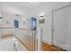 Bright hallway with hardwood floors, white railings, and doors leading to various rooms at 2311 Club Rd, Charlotte, NC 28205