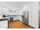 Well-lit kitchen featuring white cabinets, stainless steel appliances, and hardwood floors at 2311 Club Rd, Charlotte, NC 28205