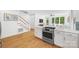 Open-concept kitchen featuring white cabinetry, stainless steel appliances, and stairs to upper level at 2311 Club Rd, Charlotte, NC 28205