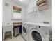 Functional laundry room with modern washer and dryer, ample shelving, and a window at 2311 Club Rd, Charlotte, NC 28205