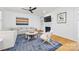 Bright living room with a fireplace, a ceiling fan, an L-shaped couch, and a stylish blue rug at 2311 Club Rd, Charlotte, NC 28205