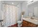 Cozy bathroom featuring a floral shower curtain and wood-look flooring at 233 E Waterlynn Rd # B, Mooresville, NC 28117