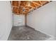 Empty garage with exposed ceiling beams and gray concrete flooring at 233 E Waterlynn Rd # B, Mooresville, NC 28117