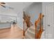 Hallway with wood floors, staircase with wood and iron railing, and views of the kitchen and dining area at 233 E Waterlynn Rd # B, Mooresville, NC 28117