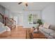 Bright living room featuring hardwood floors, staircase, and a sunlit window at 233 E Waterlynn Rd # B, Mooresville, NC 28117