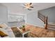 Open-concept living room featuring wood floors, neutral walls, staircase, and a breakfast bar with kitchen view at 233 E Waterlynn Rd # B, Mooresville, NC 28117