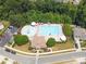 Aerial view of a community pool with a splash pad, sun loungers, umbrellas, and a well-maintained pool house at 233 E Waterlynn Rd # B, Mooresville, NC 28117