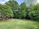 Lush green backyard with mature trees and sculpted landscaping offers a tranquil retreat at 2556 Howerton Ct, Charlotte, NC 28270