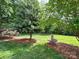 Well-manicured lawn and stone fountain accent this verdant backyard surrounded by mature trees at 2556 Howerton Ct, Charlotte, NC 28270