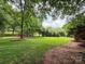 Expansive grassy backyard featuring mature trees and sculpted landscaping at 2556 Howerton Ct, Charlotte, NC 28270
