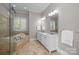 Luxurious primary bathroom featuring a double sink vanity, shower, and soaking tub with tile surround and natural light at 2556 Howerton Ct, Charlotte, NC 28270