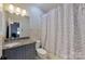 Bathroom with granite countertop vanity, toilet, and shower/tub with patterned curtain at 2556 Howerton Ct, Charlotte, NC 28270