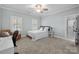Cozy bedroom with neutral walls, ceiling fan, carpet, and bright natural light at 2556 Howerton Ct, Charlotte, NC 28270