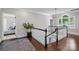 Beautiful hallway features hardwood floors, a black and white staircase, and lots of natural light coming through a window at 2556 Howerton Ct, Charlotte, NC 28270