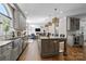 Open kitchen featuring a large island with seating, stainless steel appliances, and hardwood floors at 2556 Howerton Ct, Charlotte, NC 28270