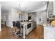 View of open kitchen with center island seating and granite countertops, with stainless steel refrigerator and appliances at 2556 Howerton Ct, Charlotte, NC 28270