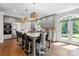 Open kitchen with large island that has seating for six, stainless steel appliances, hardwood floors, and granite counters at 2556 Howerton Ct, Charlotte, NC 28270