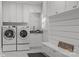 Well-organized laundry room with white cabinets, a utility sink, modern washer and dryer, and a shiplap accent wall at 2556 Howerton Ct, Charlotte, NC 28270