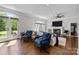 Bright living room featuring hardwood floors, a fireplace, a ceiling fan, and French doors at 2556 Howerton Ct, Charlotte, NC 28270