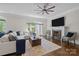 Well-lit living room featuring a fireplace, hardwood floors, ceiling fan and neutral color palette at 2556 Howerton Ct, Charlotte, NC 28270
