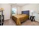 Cozy bedroom with a golden bedspread, carpet, and a bright window with natural light at 3138 Maple Ridge Dr, Gastonia, NC 28052