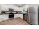 Bright kitchen with stainless steel appliances, granite counters, white cabinets, and wood-look floors offers a modern aesthetic at 3138 Maple Ridge Dr, Gastonia, NC 28052