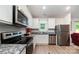 Well-lit kitchen boasts stainless steel appliances, granite countertops, and pristine white cabinets creating a modern cooking space at 3138 Maple Ridge Dr, Gastonia, NC 28052