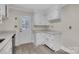 Kitchen features white cabinets and light countertops with wood-look flooring at 3733 Manchester Dr, Charlotte, NC 28217