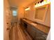 Bathroom featuring dual sinks, granite countertops, and modern lighting at 396 Pitts School Nw Rd, Concord, NC 28027