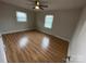 Bright bedroom featuring wood floors, a ceiling fan, and natural light from two windows at 396 Pitts School Nw Rd, Concord, NC 28027